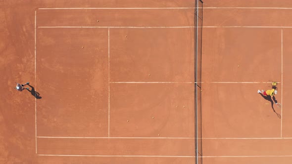 Professional Tennis Coach Training Young Woman on Red Clay Court. Aerial Top Down Drone View