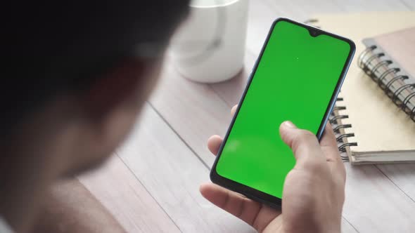 緑の画面でスマートフォンを使用して若い男の手の背面図 / Videohive, Stock footage, People