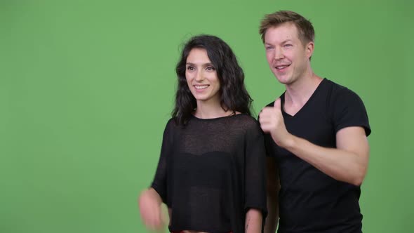 Young Couple Giving Thumbs Up Together