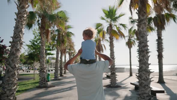 Father Carrying Son 1217 Months on Shoulders and Walking Around at Beach