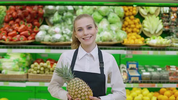 Portrait of a Young Smiling Woman Working in an Organic Store a Seller of Vegetables and Fruits
