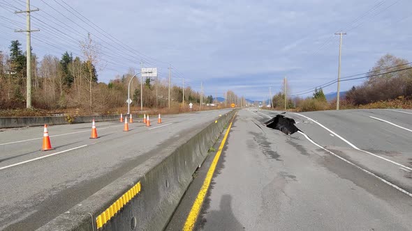 A large sinkhole and destroyed road surface along Highway 11, the recent flooding leaving behind ext