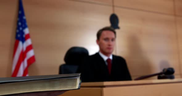 Judge looking at the witness swearing on bible