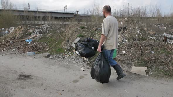 Back View of Man Looking for Plastic at Landfill