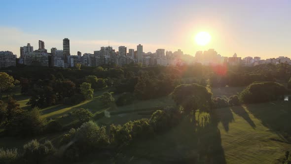 Aerial dolly out of Municipal golf lawn with Palermo neighborhood skyline in background at sunset, B