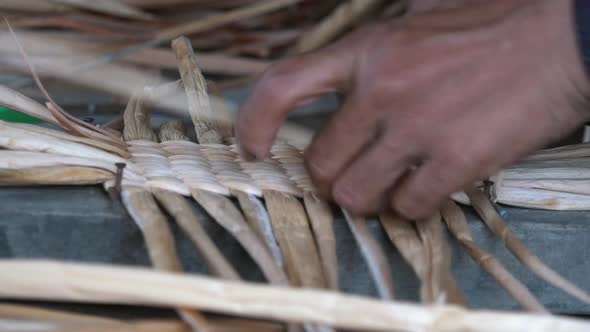 Close Shot of a Woman Weaving Palm Tree Leaf