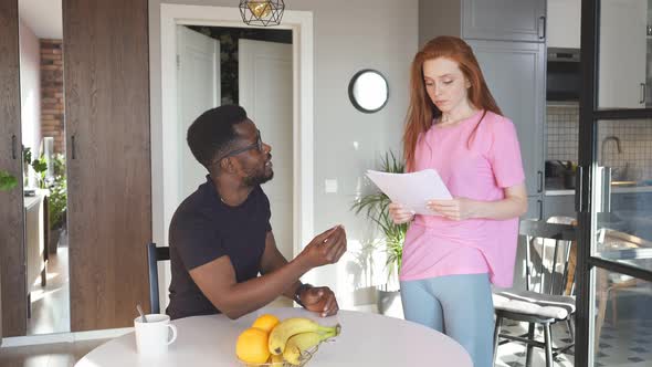 Interracial Couple Reading Mail and Checking Accounting at Home