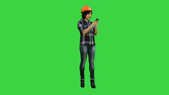 Young Asian Engineer Use Mobile Phone on a Green Screen, Chroma Key