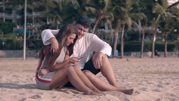 Guy Hugs Barefoot Brunette with Long Hair Waved By Wind