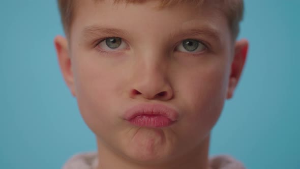 Kid disagrees by making lips grimaces and shaking head negatively