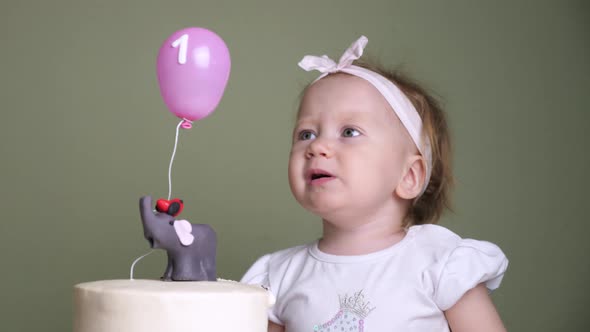 Upset child crying looking at holiday cake. One year. Birthday holiday