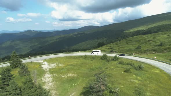 Aerial Drone View of White Bus on Mountain Road Agains Beautiful Mountains