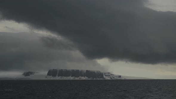 A Dark Cloud Over the Snowcovered Rocks