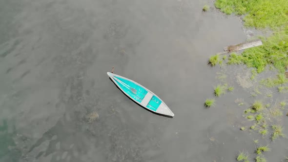 Old Blue Wooden Boat Sways on Calm Waves. Tranquility Morning on River. Top View