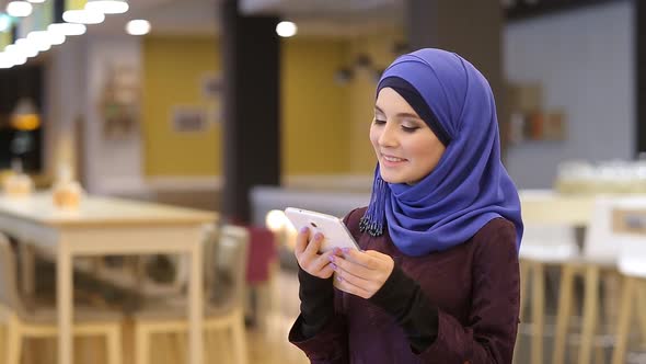Young Muslim Girl Using Tablet And Smiling At The Camera