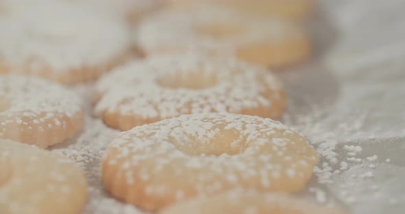 Baker preparing butter cookies with strawberry jam and powdered sugar