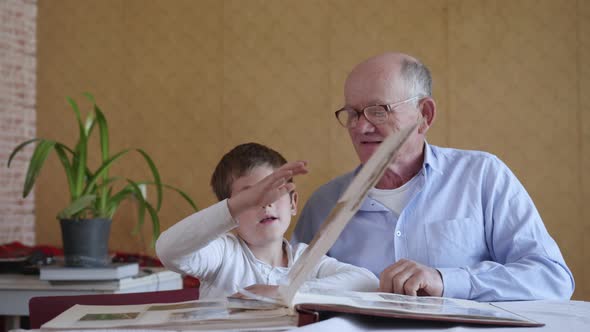 Happy Moments, Little Happy Boy with His Cheerful Grandfather Has Family Memories, Watching Photo