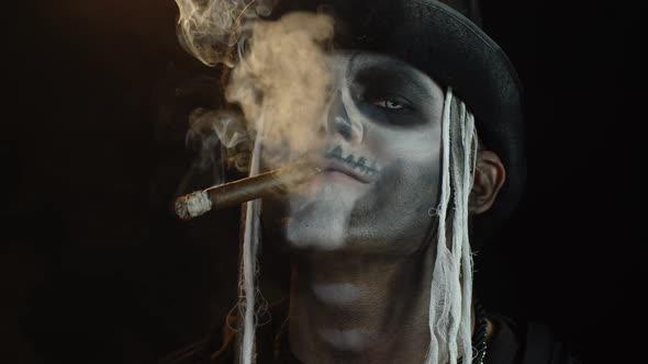 Scary Guy in Professional Carnival Makeup of Halloween Skeleton Smoking Cigar, Making Faces, Smiling