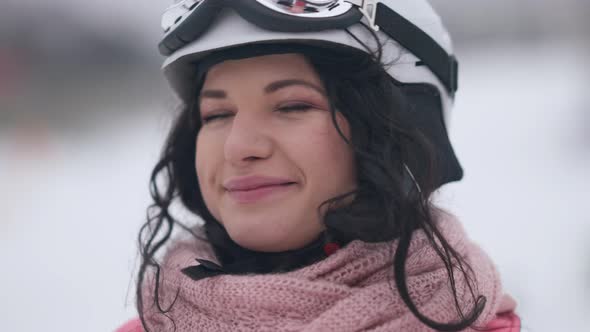 Closeup of Charming Joyful Woman Looking at Camera with Toothy Smile Putting on Ski Goggles in Slow