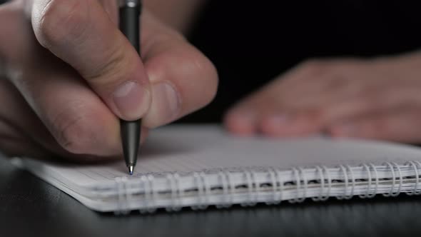 Close Up Super Macro Shot of a Man Hand Writing Something on the Paper Notebook Pencil