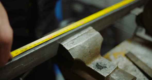 Man Working at Metal Industry - Cutting and Measuring Metal Parts at Workshop