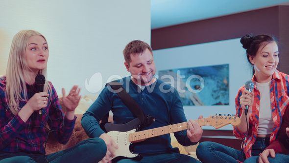 Company Funny Friends Singing with Mic and Playing Electric Guitar, Singing and Having Fun at Home