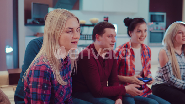 Happy Group of Friends Socializing at Home and Playing Video Game