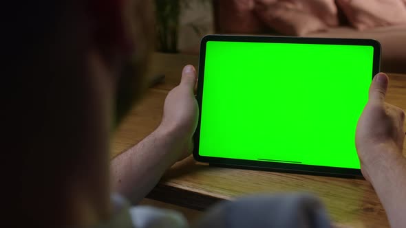 Handheld Camera Over The Shoulder View Man Using Hand Gestures on Green Mockup Screen Digital Tablet