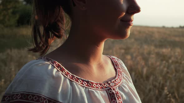 Ukrainian Woman in Vyshyvanka Shirt with Traditional Ornament Standing in Wheat Field