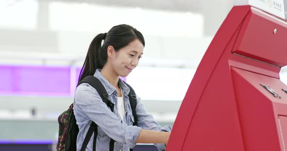 Woman using selfie check in machine in the airport 