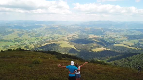 A man photographs a mountain landscape while hiking in the mountains.