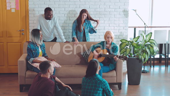 International Company of Friends Playing the Guitar and Singing Songs