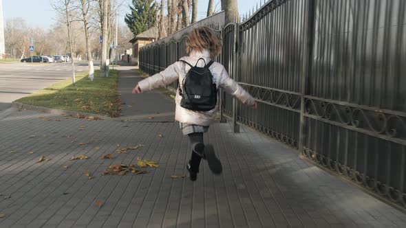 Happy Schoolage Girl Running Bouncing on Her Way Home