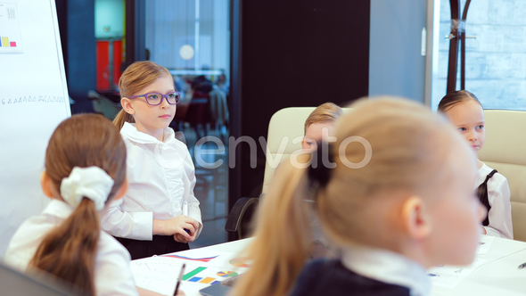Young Businesswoman in Glasses, Standing Next To a Flip Chart, Tells a Business Plan. Business