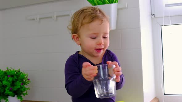 Baby in the Kitchen with a Glass of Water