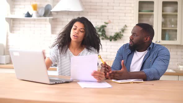 Worried Multiracial Couple Looking Through Utility Bills