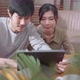 husband and wife discussing paper bill receipt from tablet laptop together on the floor - VideoHive Item for Sale