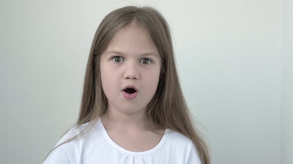 Surprised Little Girl in White Tshort on Gray Background