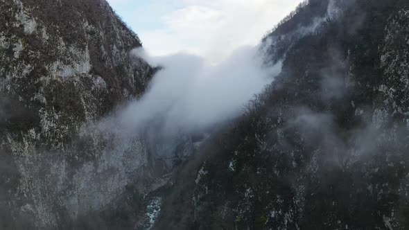 Drone View of the Dense Fog Creeping Along the High Cliffs in the River Valley