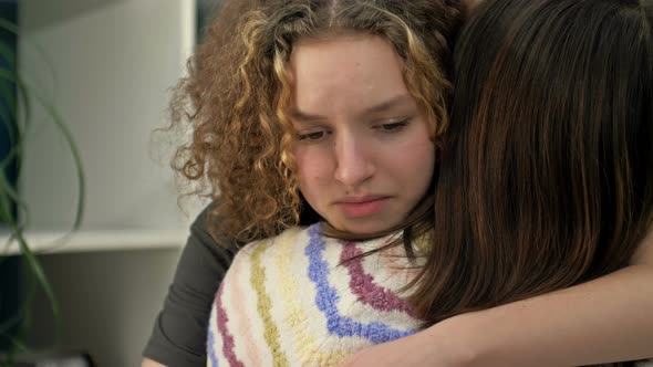 Teenage Girl is Crying Bitterly on the Shoulder of Her Mother or Friend