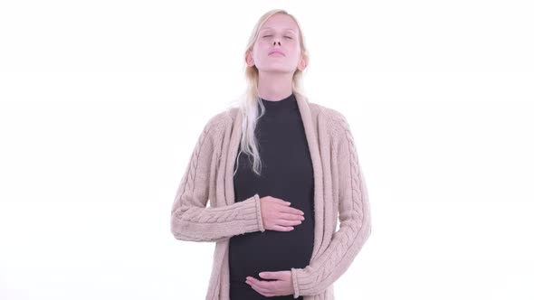 Happy Young Blonde Pregnant Woman Relaxing with Eyes Closed