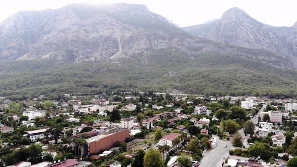 Aerial View of the Town at the Foot of the Treecovered Mountains and the Central Road with a Cluster