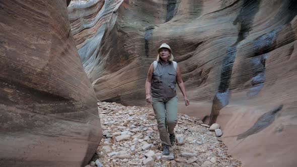 Tourist Walks Along A Picturesque Narrow Canyon Gorge With Curved Wavy Walls