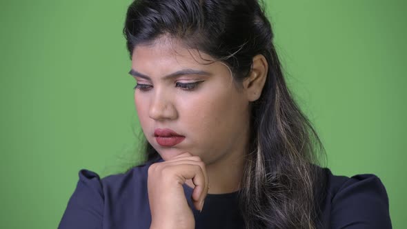 Young Overweight Beautiful Indian Businesswoman Against Green Background