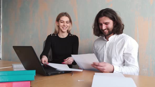 Man and Woman Collegues Working with Papers at Office