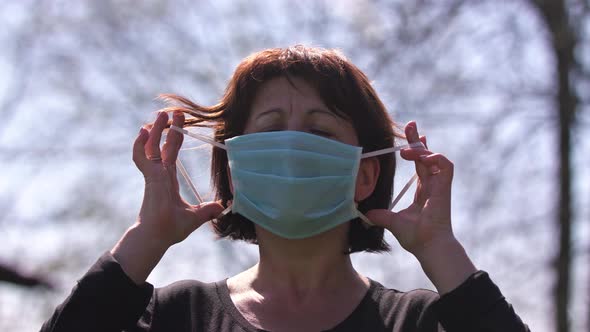 Woman Takes Off Medical Mask Outdoor. Breathes Deeply and Smiling Looking at Camera. Health Care and