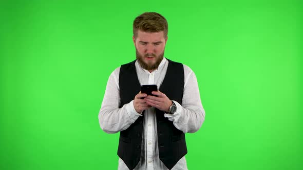 Man Angrily Texting on His Phone on Green Screen.