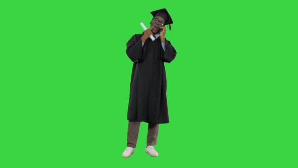 Smiling African American Male Student in Graduation Robe Talking on the Phone Sharing Happy News 