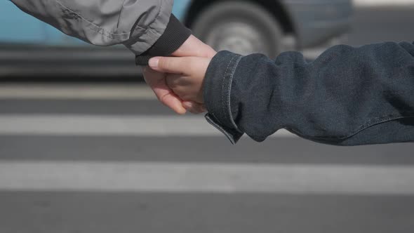 Female and kid wait to cross the road. 