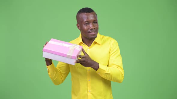 Young Happy African Businessman Shaking Gift Box